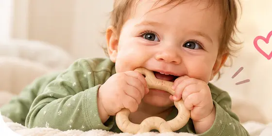 Diş kaşıyıcısı kullanan gülümseyen bebek